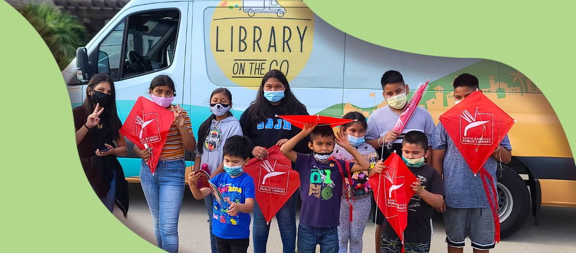 children around library van with kites