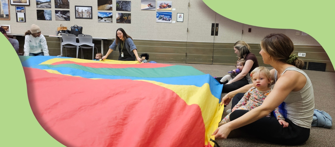 Librarian and families playing with a parachute