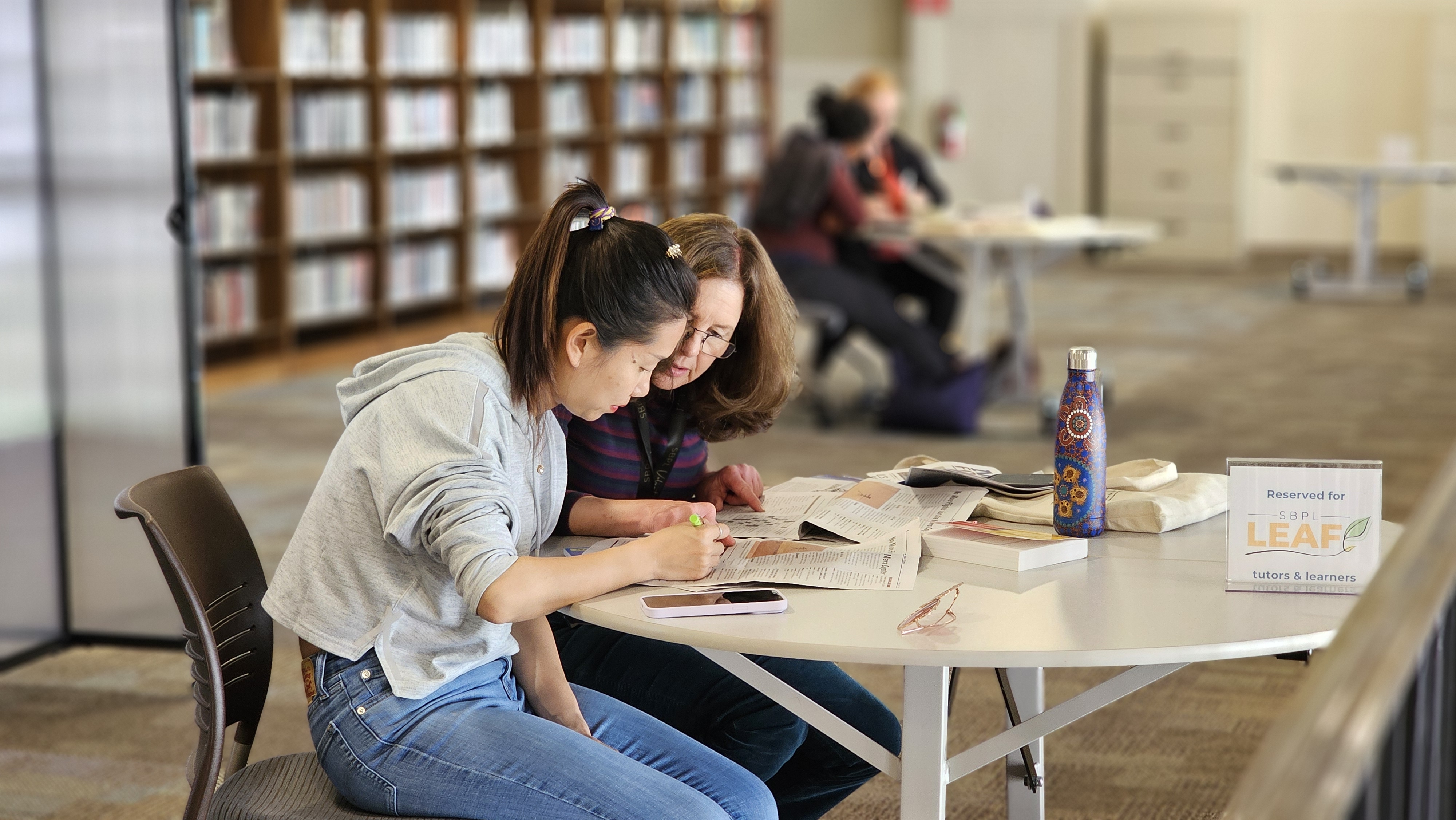 woman sitting at table with tutor.