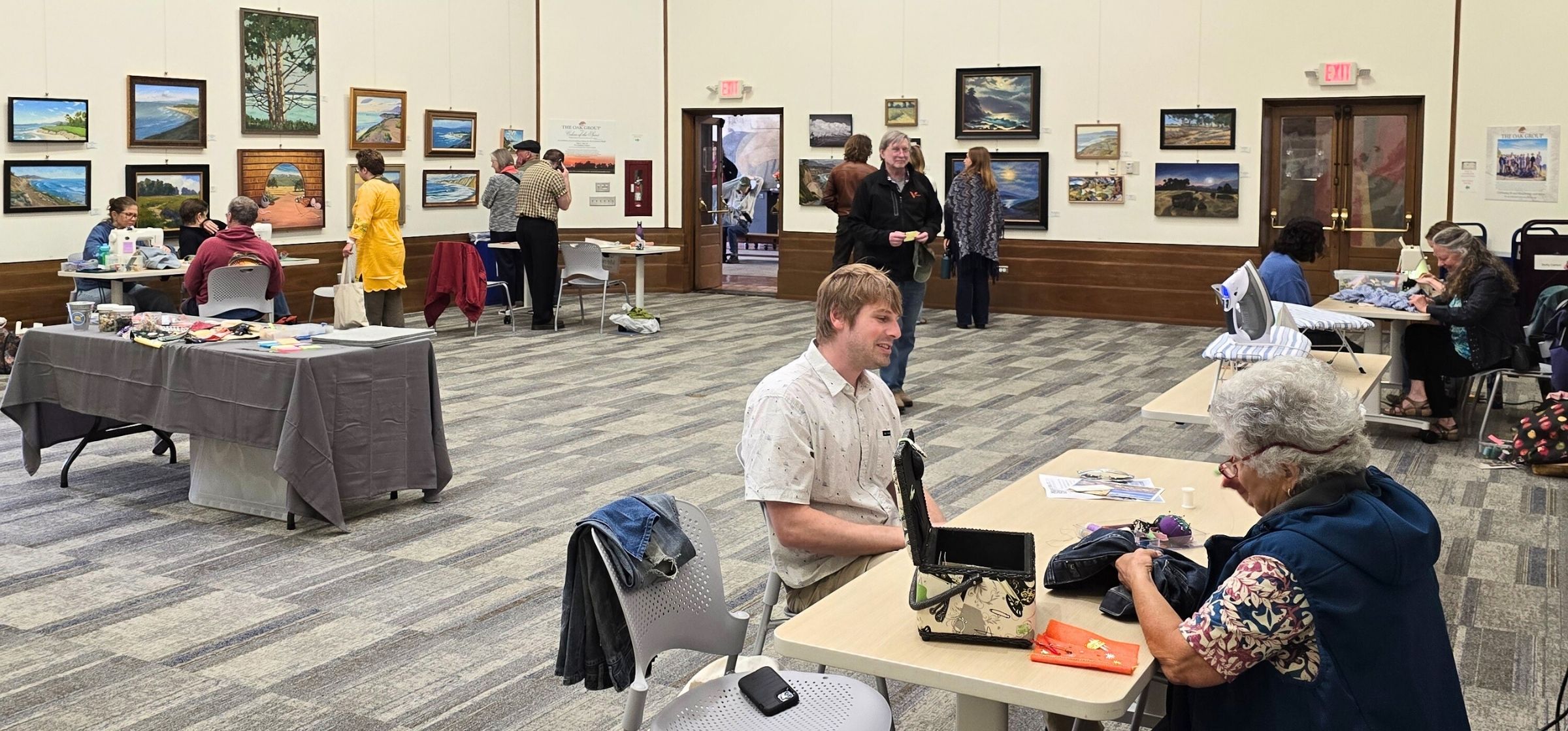 Volunteers assist patrons in mending items at the Fix-It Fair