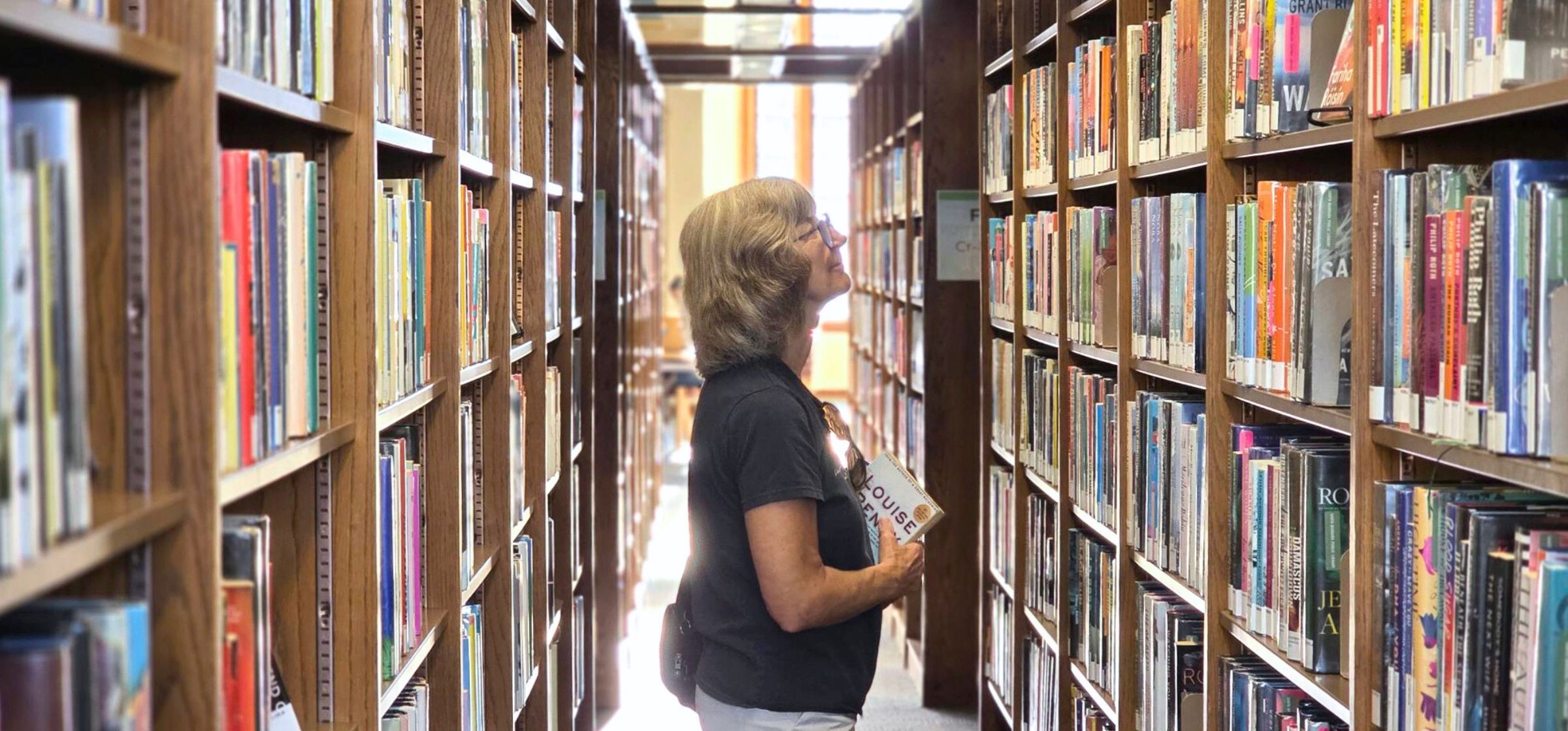 Patron browsing library shelves at the Central Branch