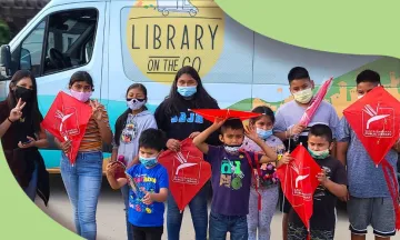 children around library van with kites
