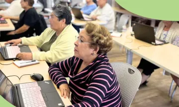 patrons sitting at tables with computers