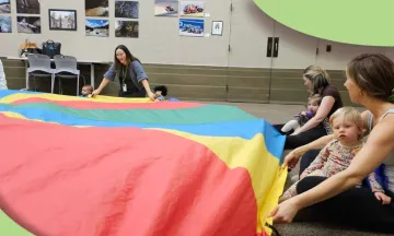 Librarian and families playing with a parachute