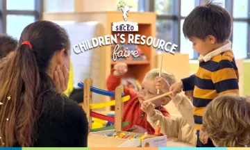 children sitting around and playing at a table in the library