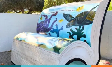 Concrete bench in the shape of a book with painted with ocean seascape