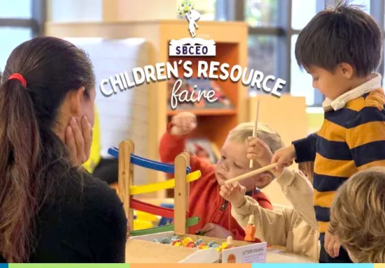 children sitting around and playing at a table in the library