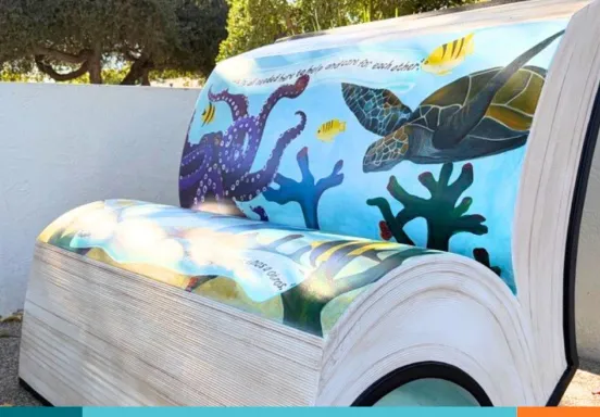 Concrete bench in the shape of a book with painted with ocean seascape