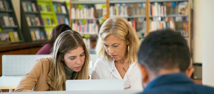 Two women using a computer in a library