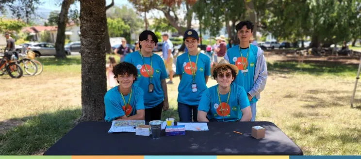 teens standing at a table outside