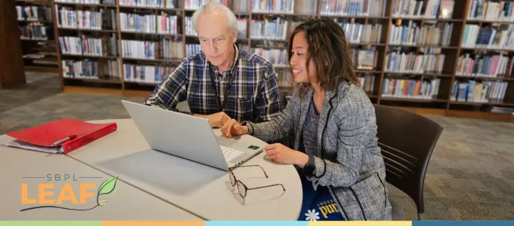 tutor sitting at table with learner at the library