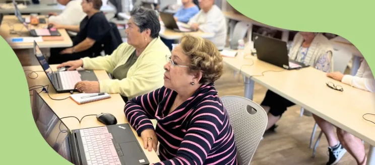 patrons sitting at tables with computers