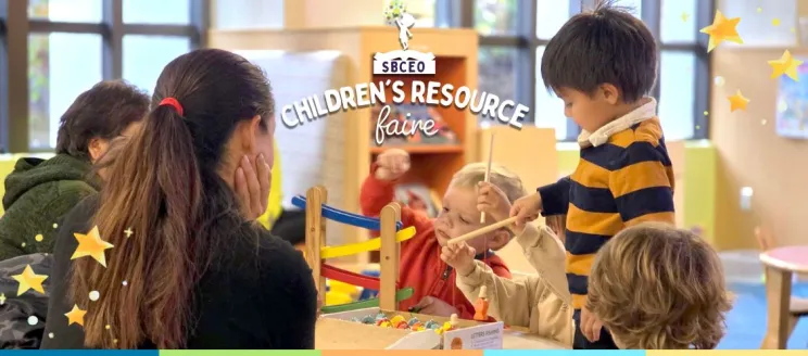 children sitting around and playing at a table in the library