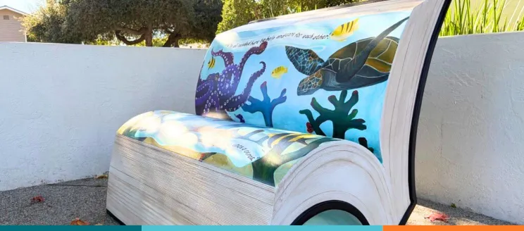 Concrete bench in the shape of a book with painted with ocean seascape