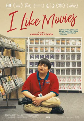A home movie rental employee sits on the store floor