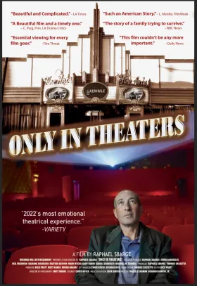 A man sits in a movie theater gazing at the screen