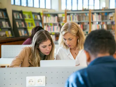 Two women using a computer in a library